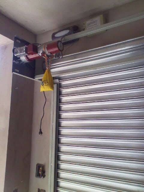 motor vermelho de porta de enrolar instalado com controle amarelo